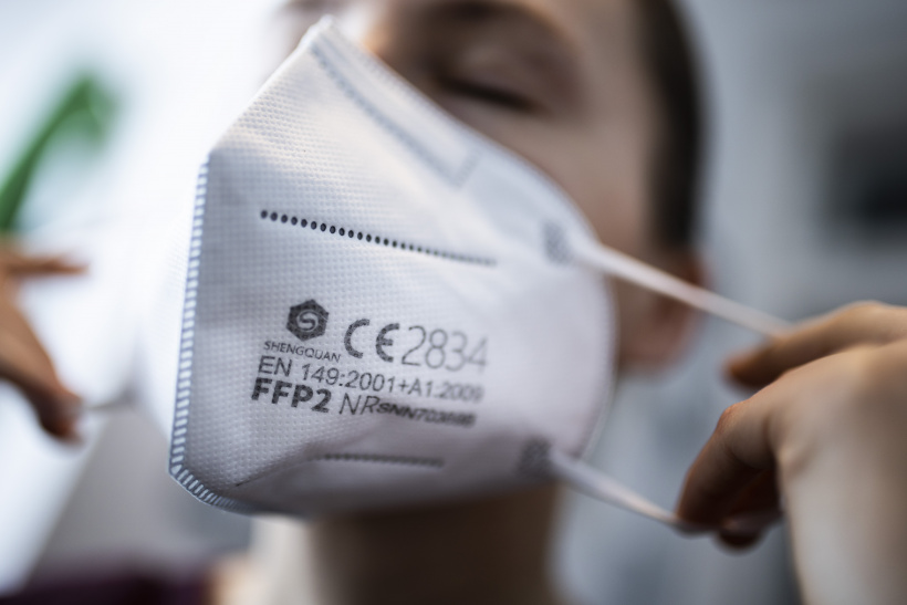 FFP2-Maske wird aufgezogen FFP2-Maske wird aufgezogen
