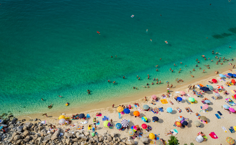 Türkisblaues Meer und ein Strand voller Touristen Türkisblaues Meer und ein Strand voller Touristen