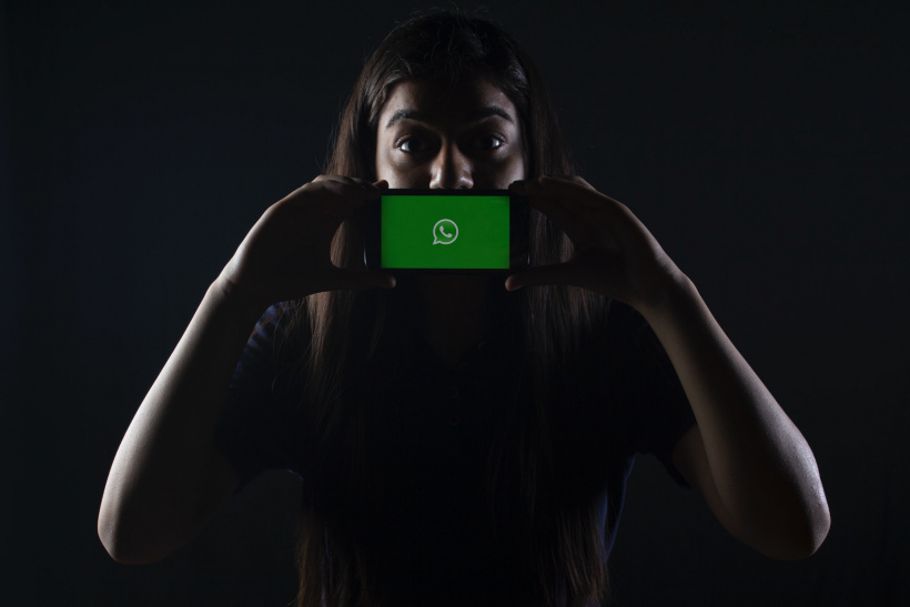 Frau mit Handy und WhatsApp-Icon Frau mit Handy und WhatsApp-Icon